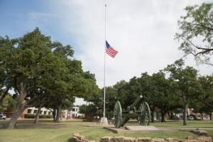 American Flag on a pole next to a cannon on campus